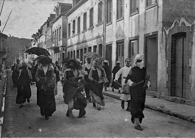 Fort-de-France. Scène de carnaval. Petit groupe de personnes déguisées défilant dans une rue et jouant du t